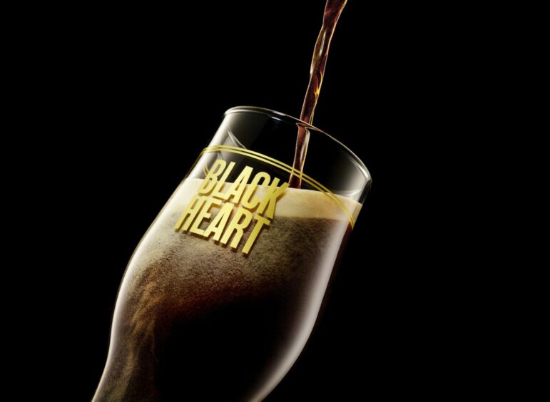 Black Heart beer by BrewDog is being poured into a glass in front of a black backdrop, served at Taste of Grampian 2023.