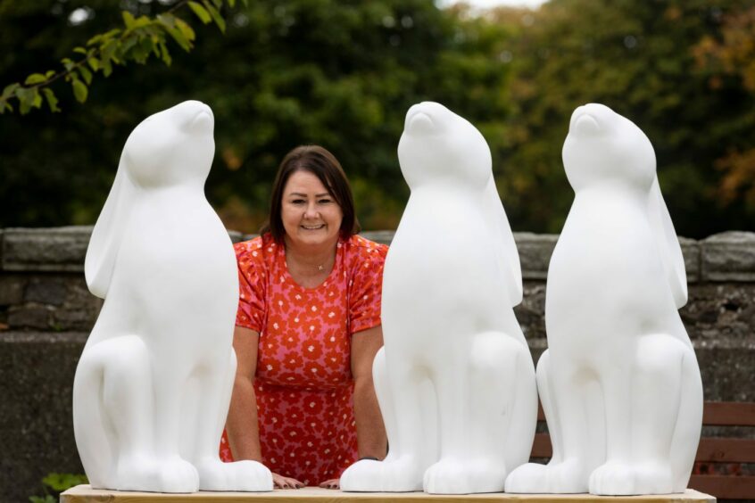 Teresa Bremner, Clan's sculpture trail manager, with three hare statues.