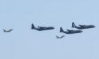 Three Hercules planes in formation flanked by two Typhoon jets.