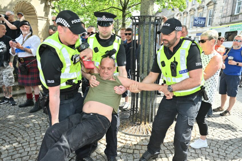 A man and a woman were forcibly removed after refusing to cooperate with police orders. Image: Jason Hedges/DC Thomson