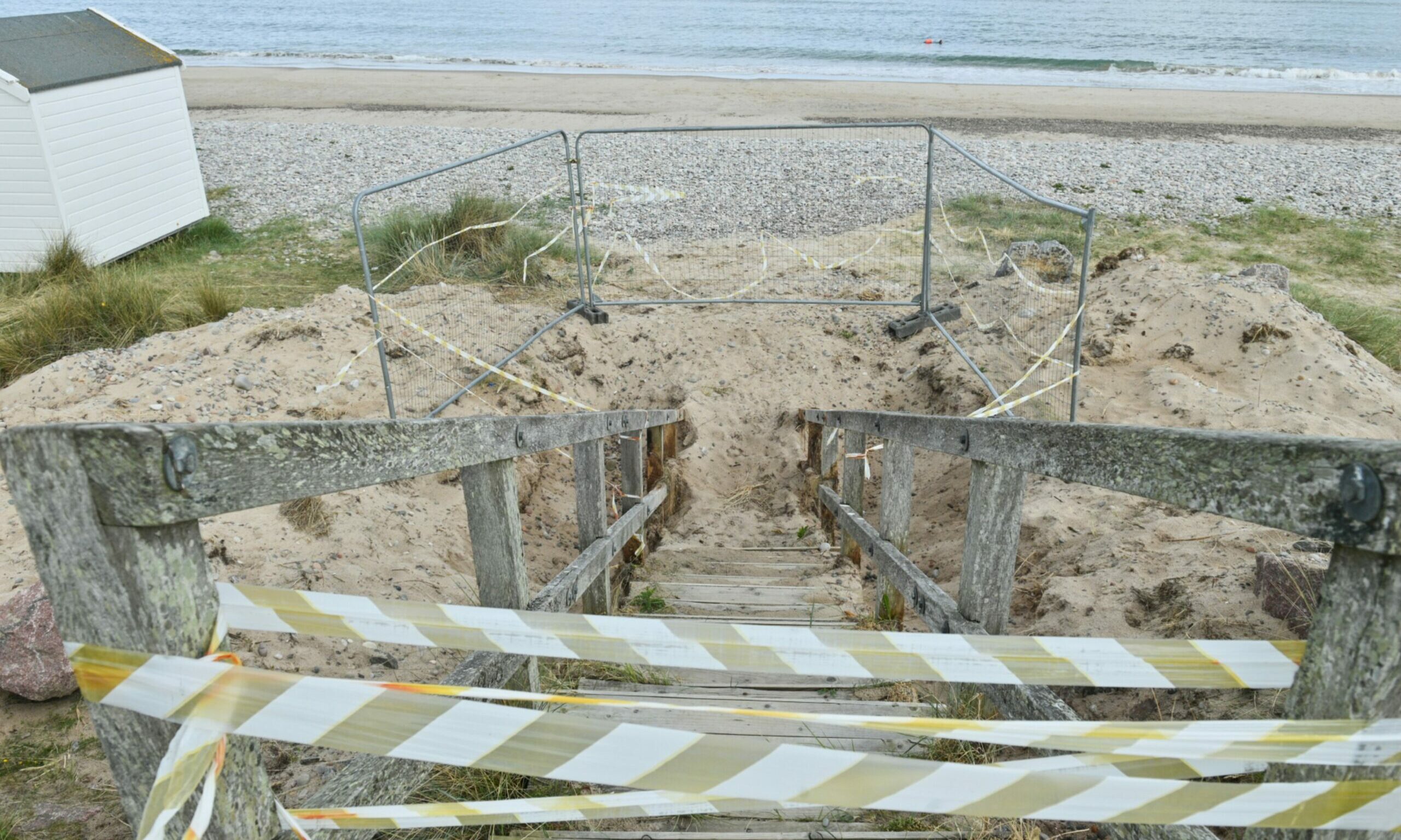 Looking down from the top of a set of the Findhorn beach steps that are sealed off with red and white tape. 