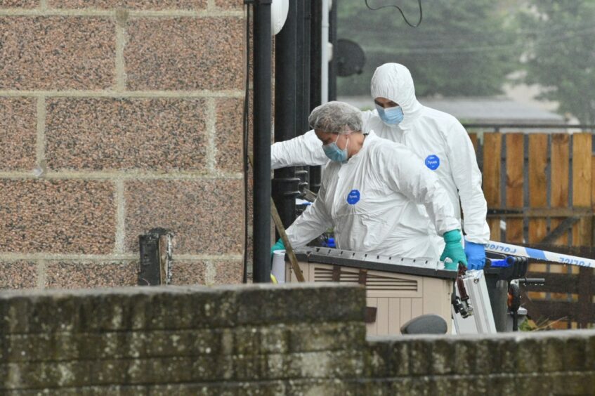 Forensic officers arrive at the Peterhead home where the death of a woman has been confirmed.