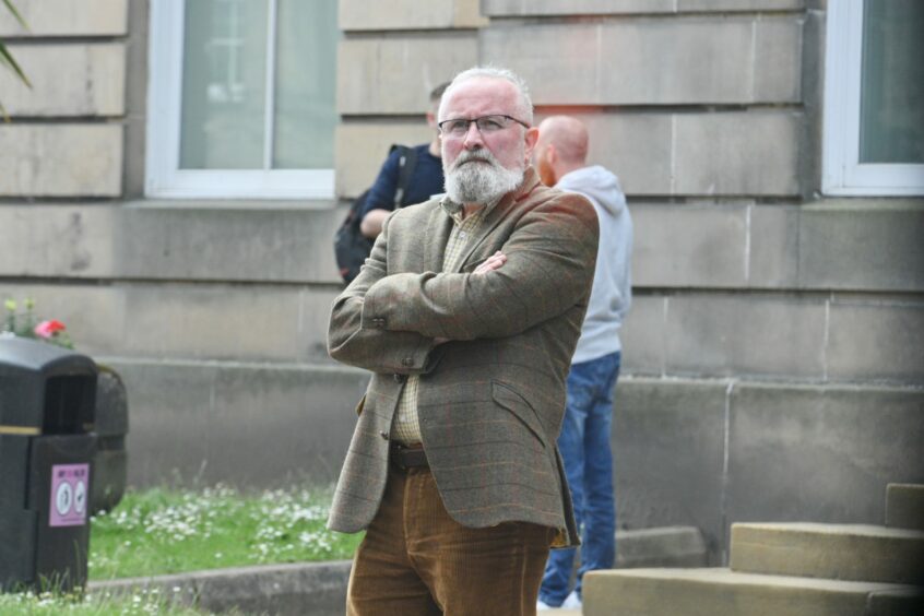 Gairloch High School science teacher Dr Michael Close is pictured leaving Elgin Court with his arms crossed.