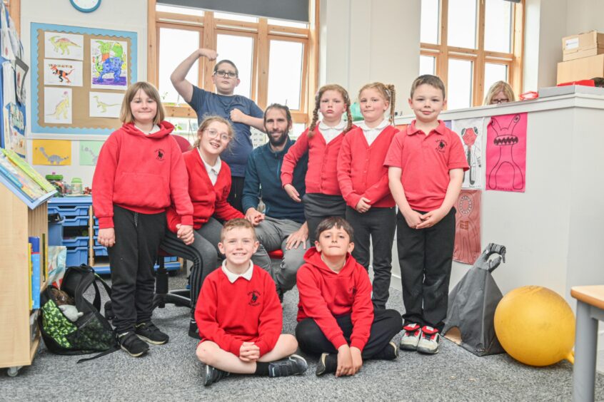 Javi Cabrera Valdes and some of his pupils in red uniforms at Dalneigh Primary School in Inverness.