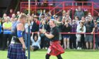A crowd cheering on competitors at the Inverness Highland Games.