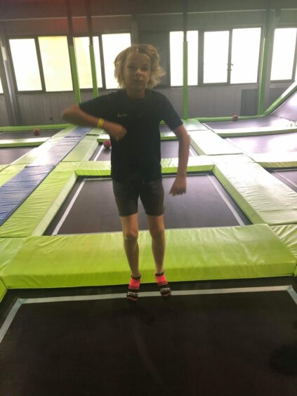 Child bouncing on trampoline.