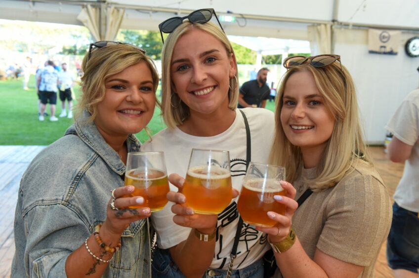 Chloe Dawson, Kirsty Lockhart, Georgia Lanning at the Midsummer Beer Happening, each holding a glass of beer.
