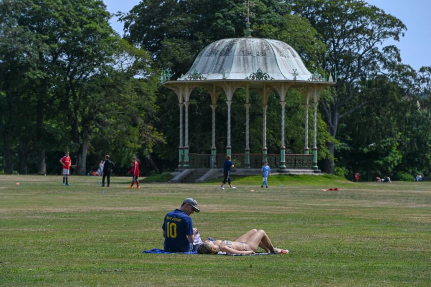 Two people lying on the grass at Duthie Park. 
