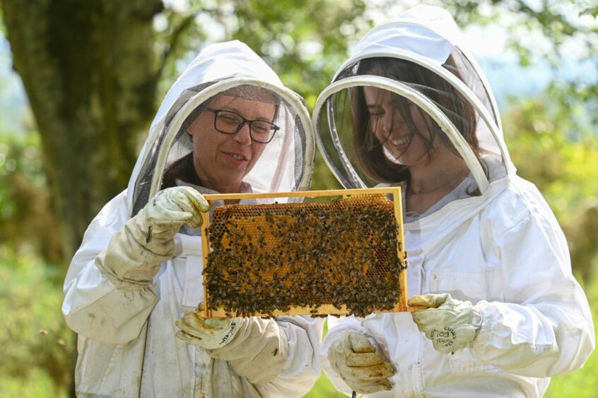Kaya Malinowska and her mum Anna holding a honeycomb.