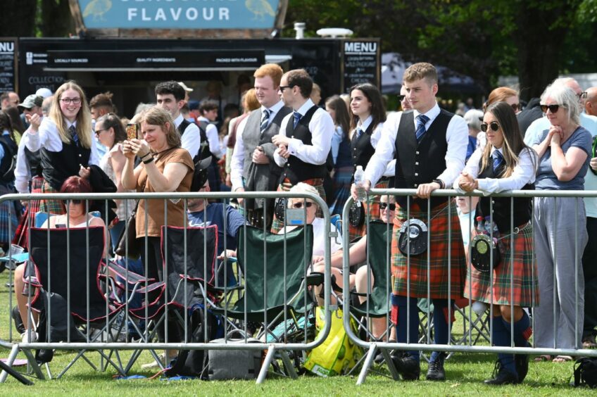 Other pipe band members watch the other competitors.