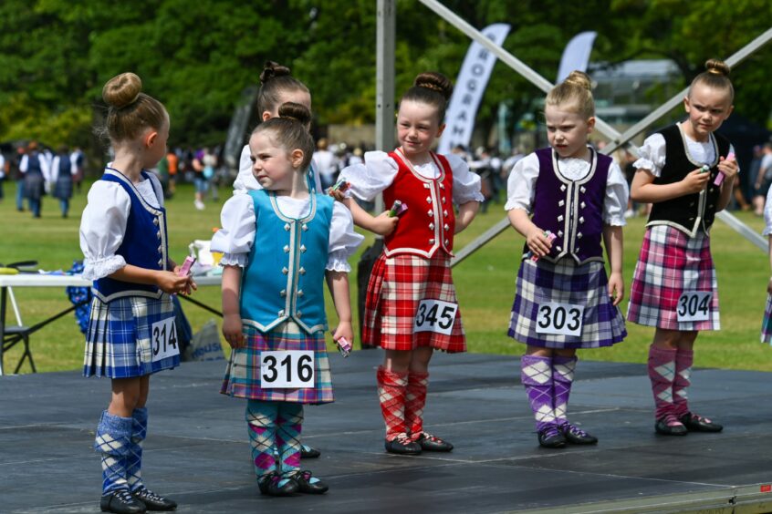 Young Highland dancers on stage.