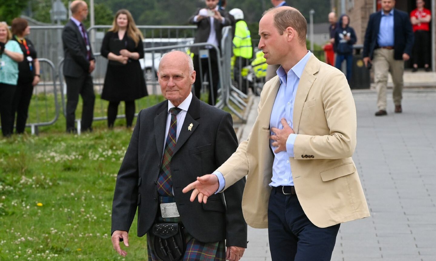 Prince William walking along a path speaking to Aberdeen Lord Provost David Cameron. 
