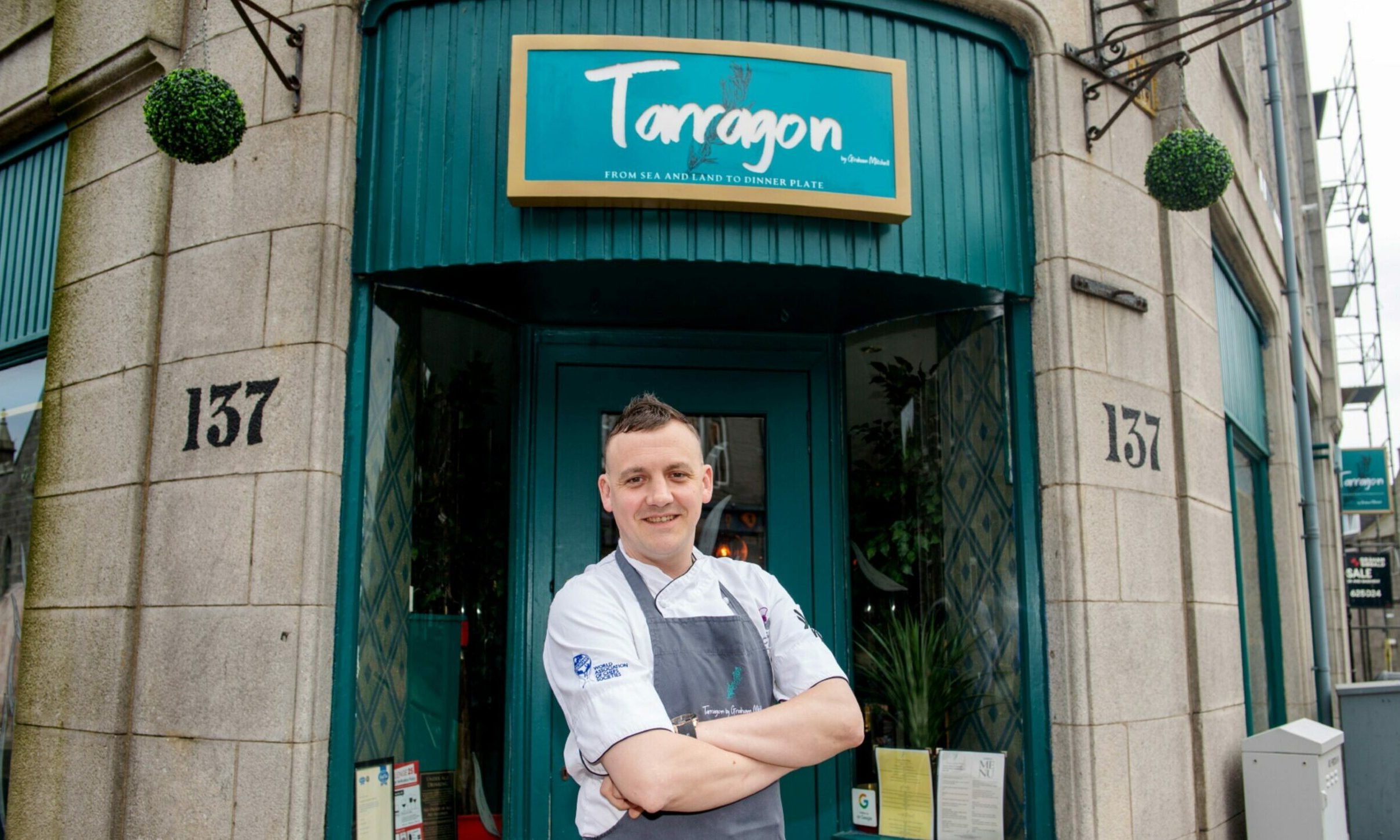 Graham Mitchell standing outside the doorway of Tarragon