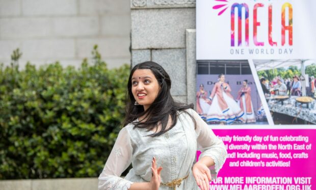 Dancer Shahwati Vinod perfroming outside Marischal College in front of a Mela banner