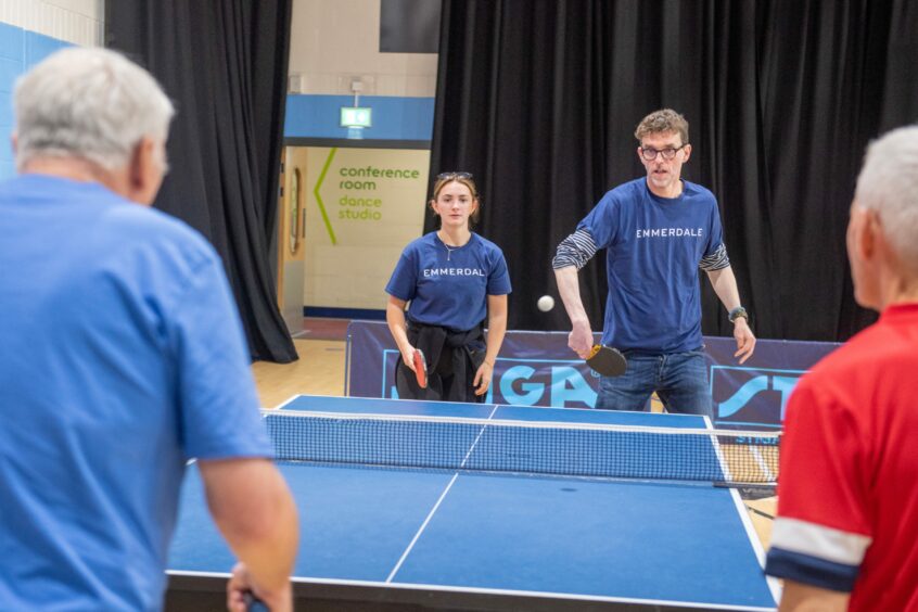 The Emmerdale table tennis team Mark Charnock and Rosie Bentham who were playing Hamish Vernal (blue) and John Percival (red) .