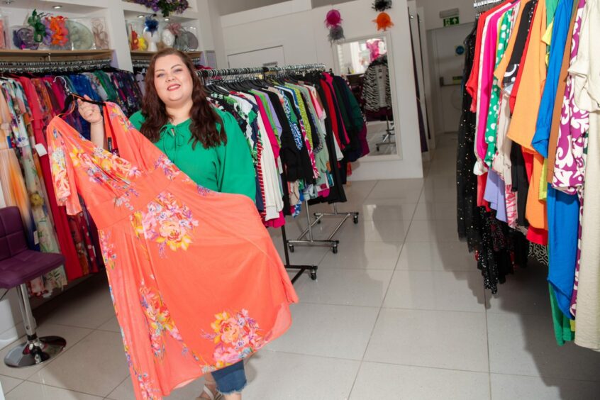 Owner Victoria holds a dress inside her size inclusive clothing store in Aberdeen.