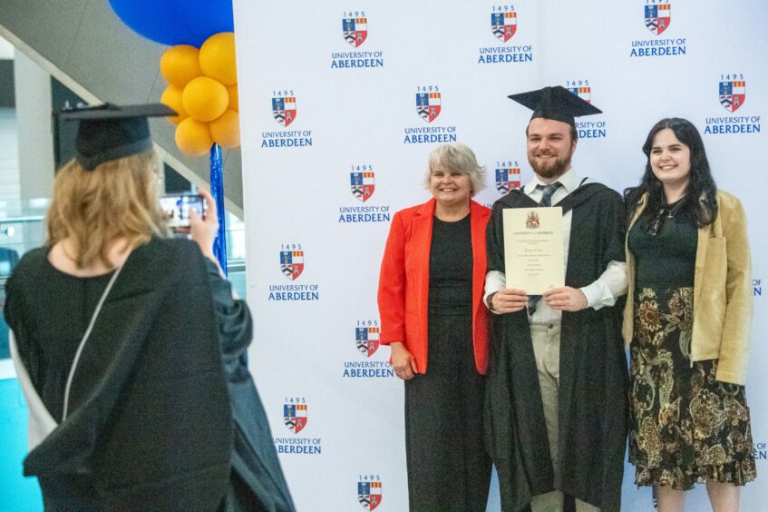 Graduate getting a photo with loved ones.