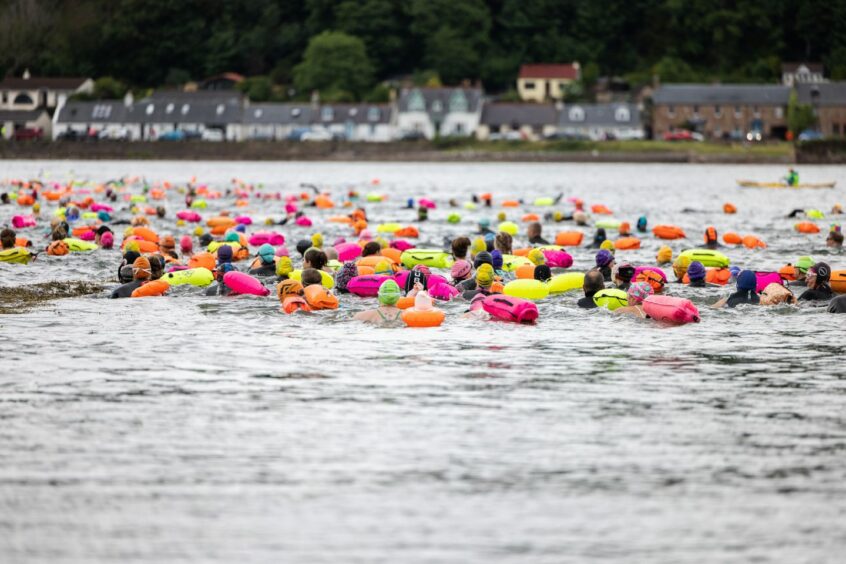 Participants swimming in colourful caps at Kessock Ferry Swim 2023.