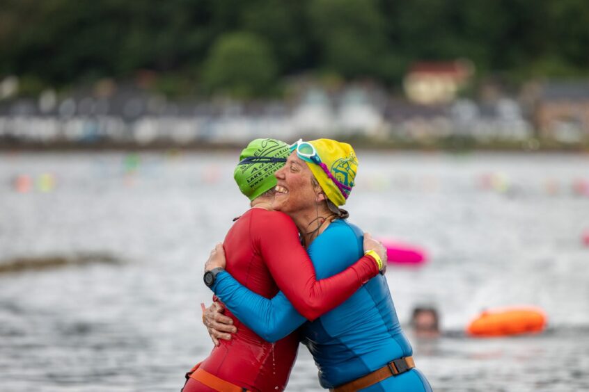 Swimmers congratulate each other on making it to the finish line.