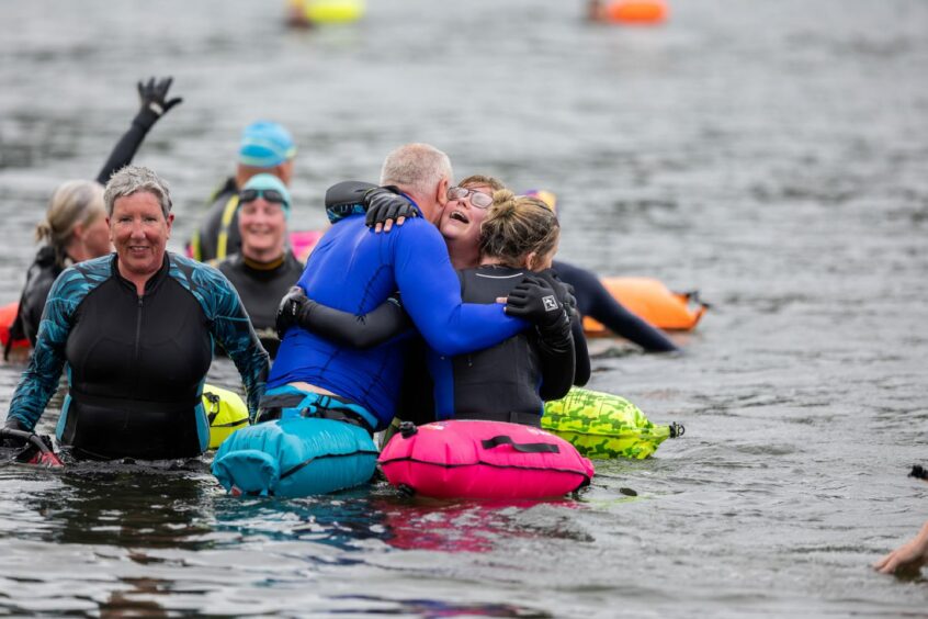 Swimmers hug as they complete the Kessock Ferry Swim.