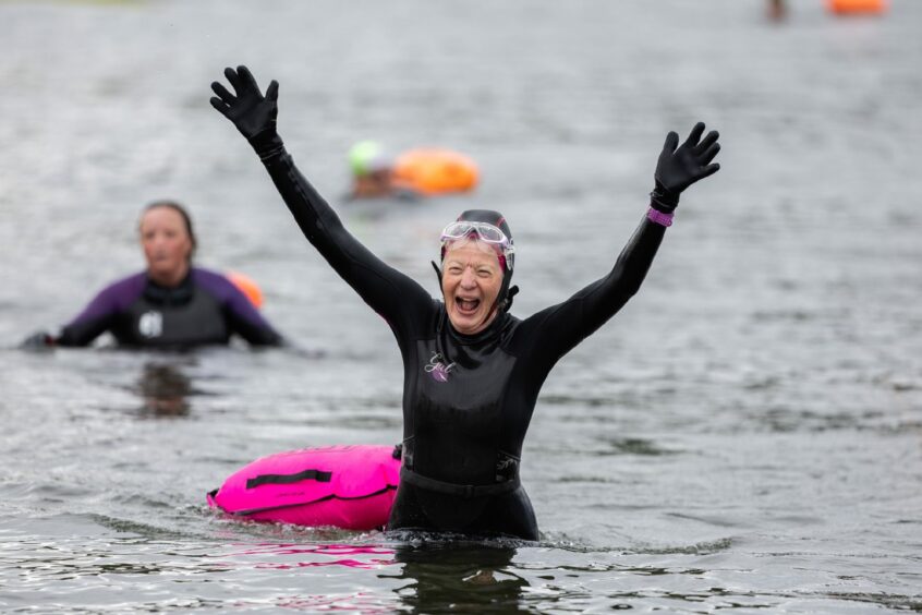 Swimmer cheers as she makes it to the other said of the Moray Firth.