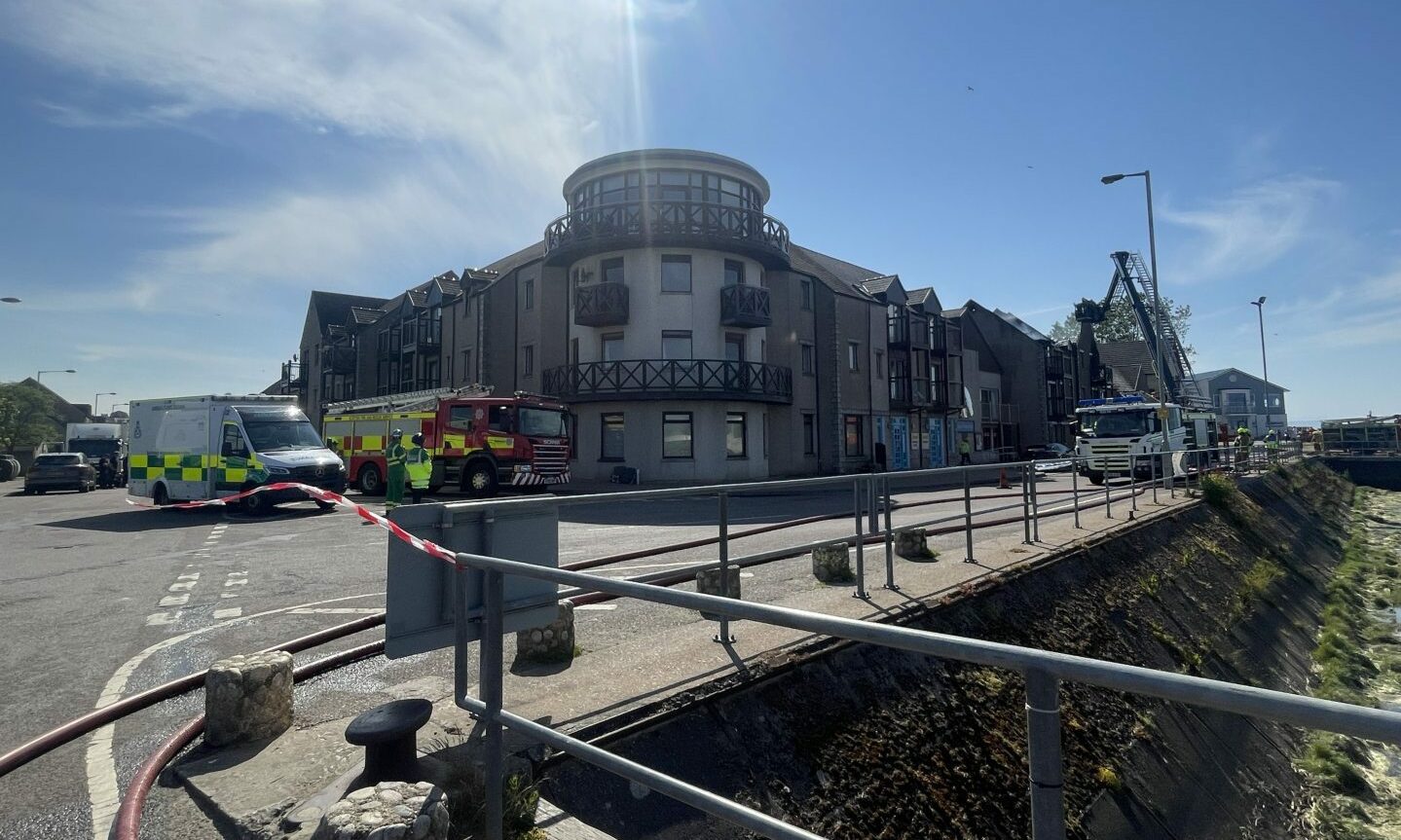 View from harbour looking at building that has been affected by fire and surrounding streets. 