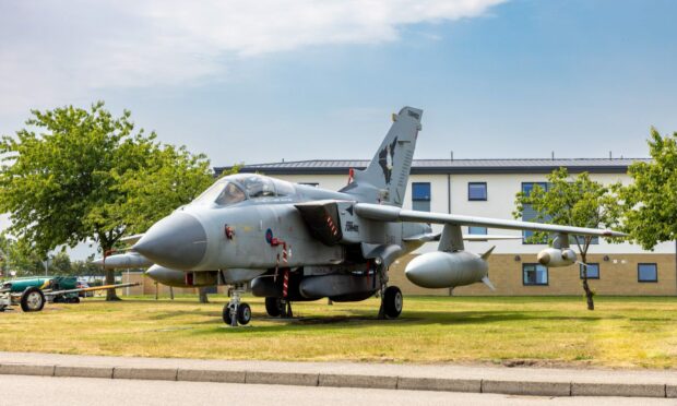 Tornado jet on the grass next to side of the road at RAF Lossiemouth.