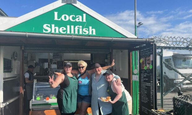 Oban Lesbian Weekend founder Maz Gordon, (second from right) with staff from her dad's shop, a highlight for many attendees. From left, Alanna MacKenzie, Fiona Dow and Meggie Pick.  Image: Supplied.