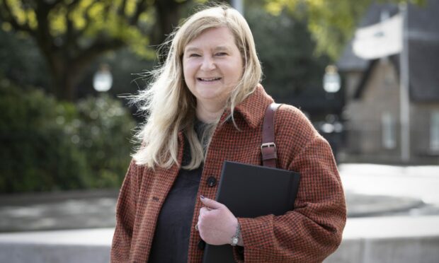 Jenni Minto outside the Scottish Parliament clutching a tablet computer under her arm.