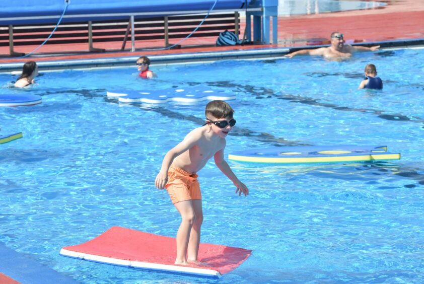 Little boy surfing on paddling board.