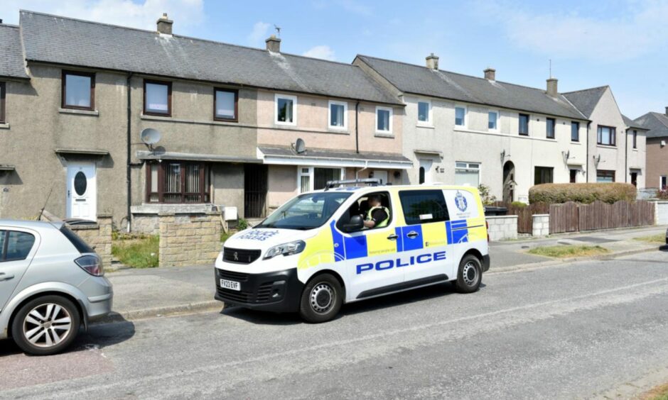 A police van parked outside houses.
