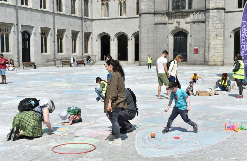Kids getting involved in the Chalk Don't Chalk event at Marischal College.