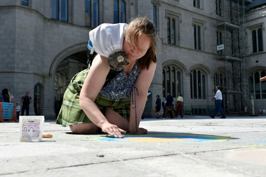 Woman creating art with chalk.