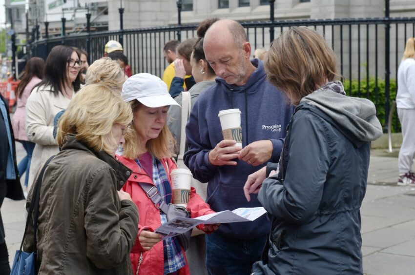 Group of people reading information about Nuart.