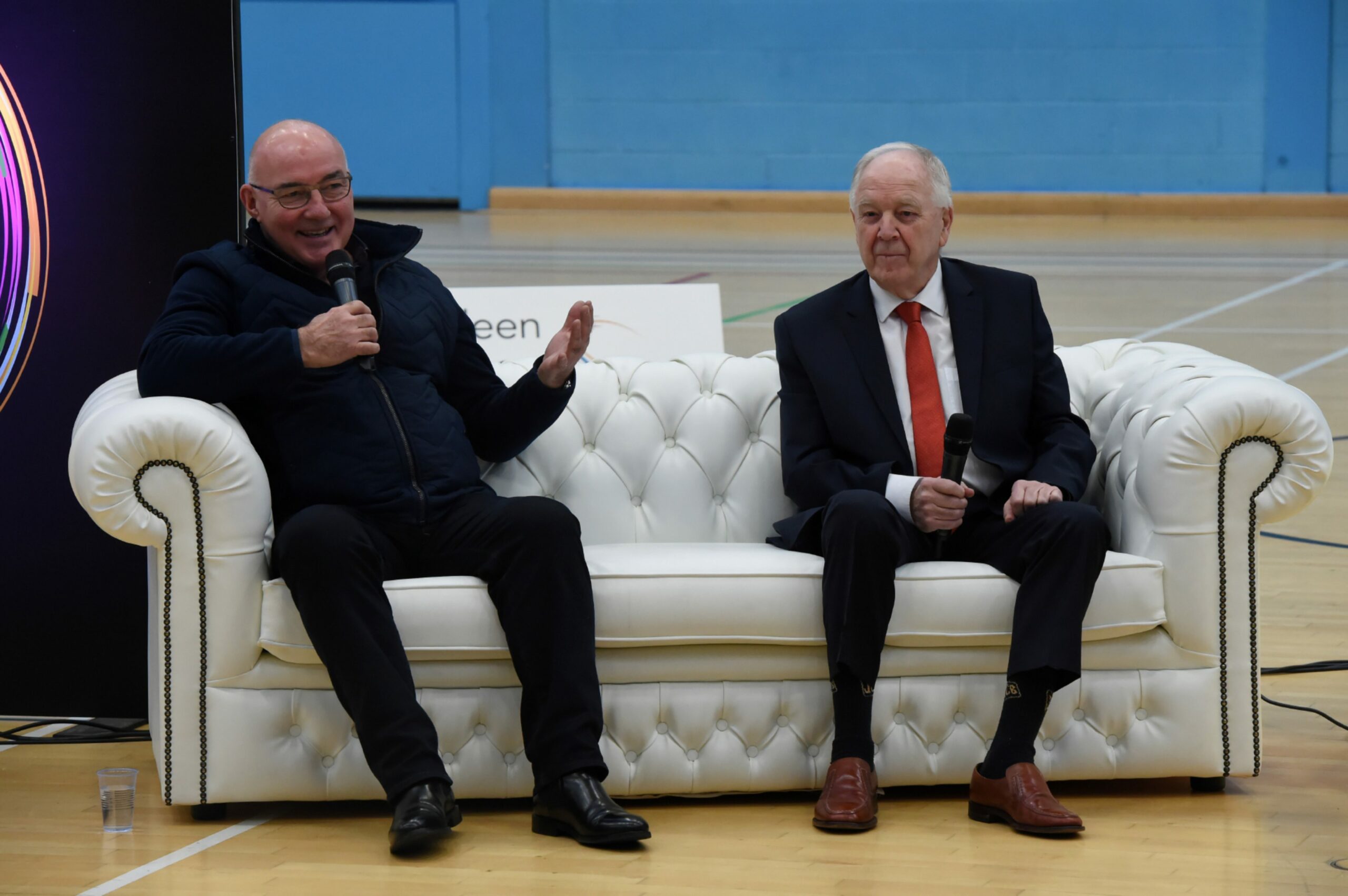 Willie Miller and Craig Brown on a white chesterfield sofa with microphones