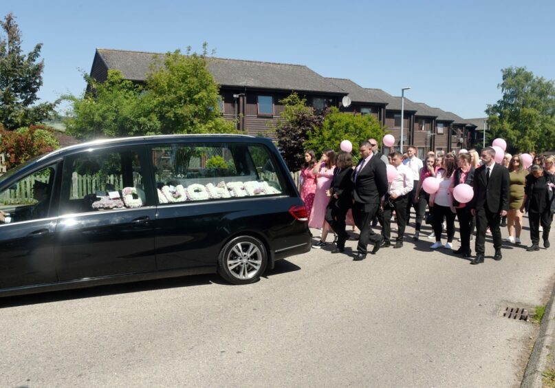 Around 100 people from Milnafua wore pink and carried balloons behind Hannah and Connor as part of the funeral cortege of little Mia. Image by Sandy McCook / DC Thomson.