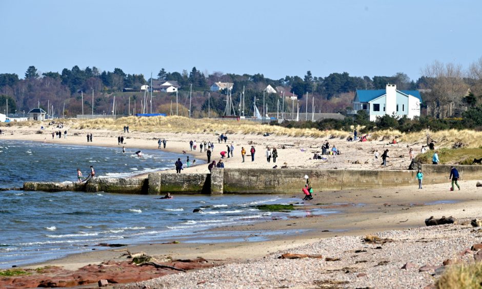 People on Nairn beach on sunny day. 