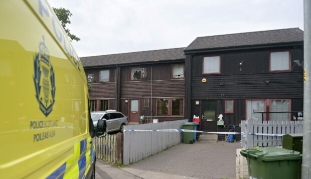 A police presence remains outside a house on the Milnafua housing estate, Alness. Image: DC Thomson