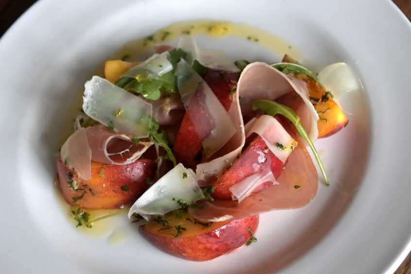 New season nectar peaches with Parma ham, shaved Manchego and a gremolata dressing.