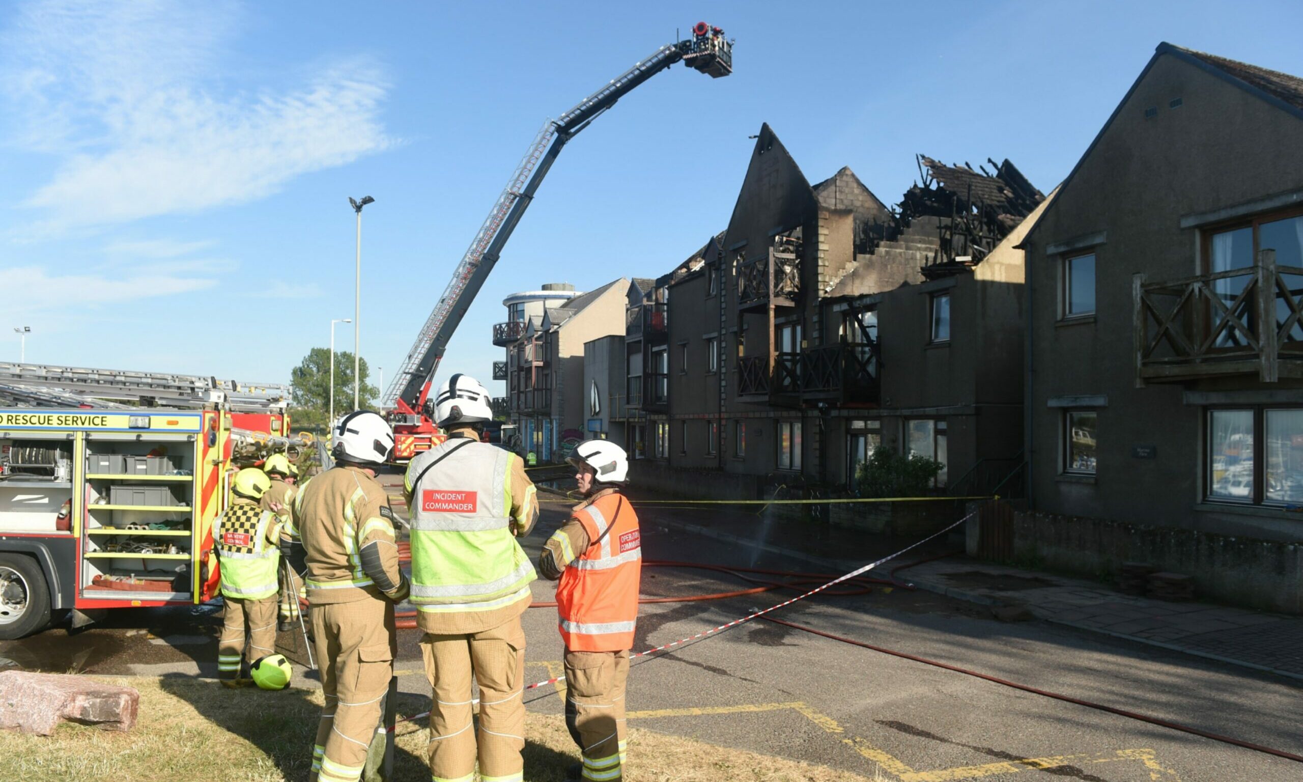 Fire crews in conversation in front of the Harbour Street building. 