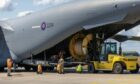 A big reel of cabling being loaded into the back of a plane by a yellow forklift truck at RAF Lossiemouth.