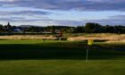 A wide shot of a golfer on the Struie Course