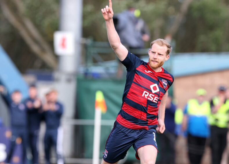 Ross County's Josh Sims running with one hand arm up in celebration