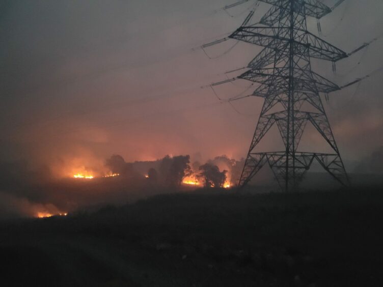 Firefighters battled poor visibility to extinguish fires burning near electricity pylons.