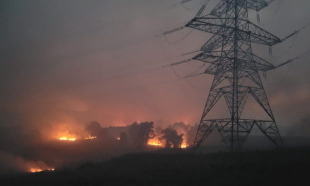 Firefighters battled poor visibility to extinguish fires burning near electricity pylons.