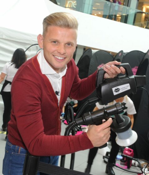 Jeff Brazier standing and holding a TV camera.