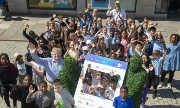 Aberdeen City Council Co-leader Councillor Ian Yuill with pupils from Hannover Primary School enjoying Clean Air Day with street entertainers the Hedge Men.