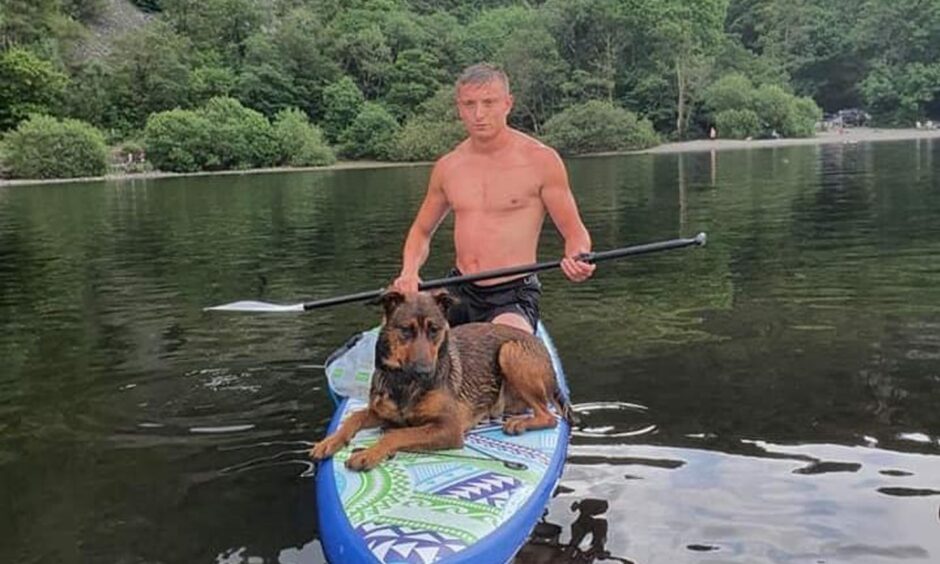 Michael Jenkins on a paddleboard with his dog 