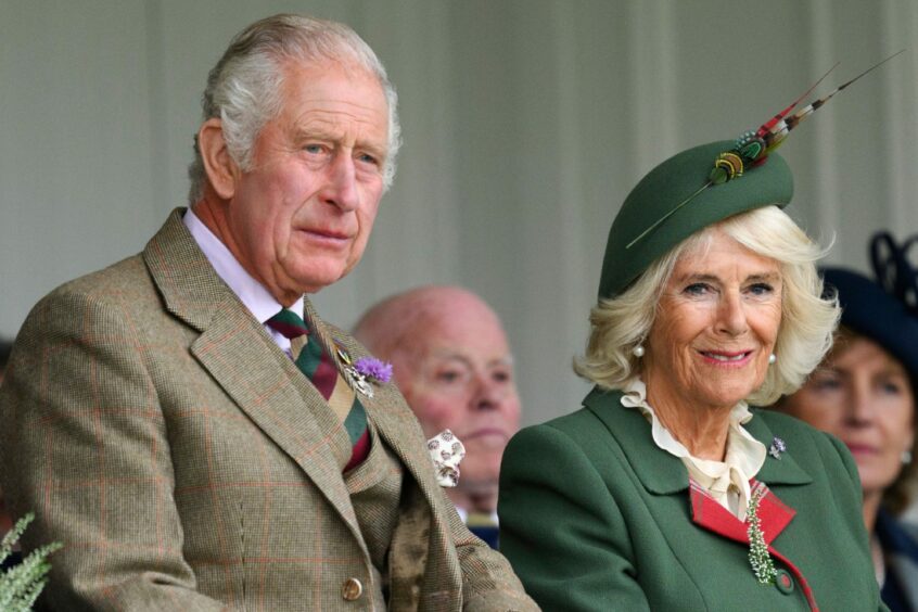 King Charles and Queen Camilla sitting and watching on.