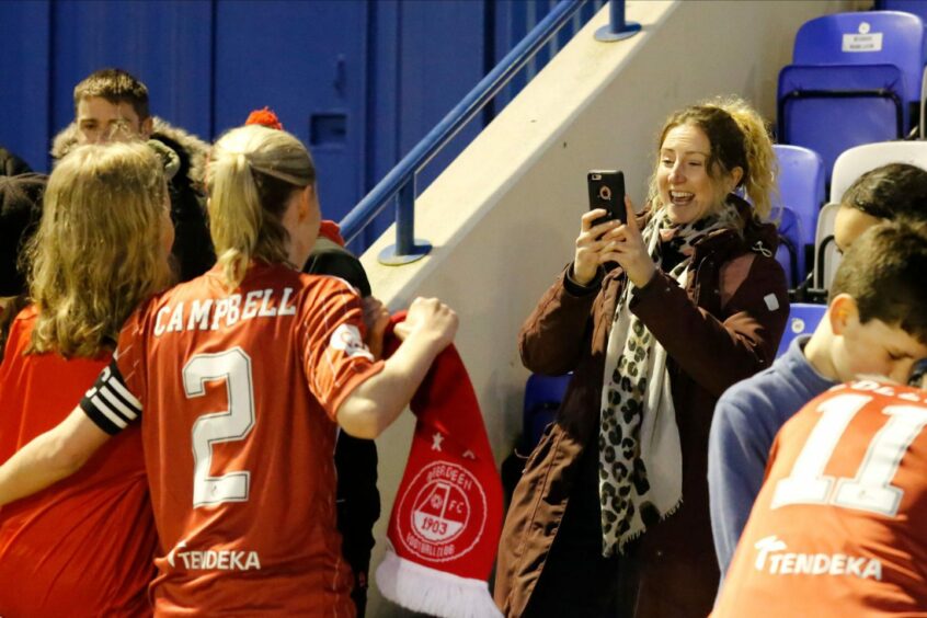 Loren takes pictures with a fan after her final home game for Aberdeen in May. 